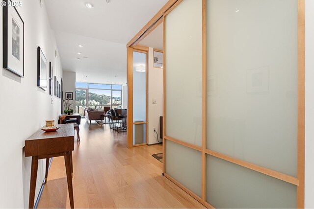 corridor with light hardwood / wood-style flooring and a wall of windows