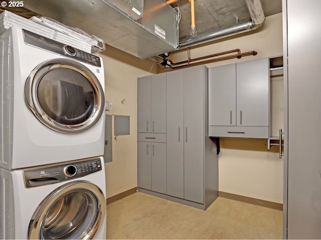 laundry room featuring stacked washer / drying machine