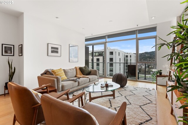 living room with floor to ceiling windows and light hardwood / wood-style flooring