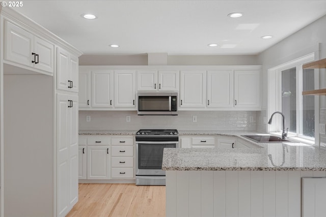 9240 SW Stono Dr, Tualatin, OR 97062 - kitchen featuring appliances with stainless steel finishes, white cabinetry, a peninsula, tasteful backsplash, and recessed lighting
