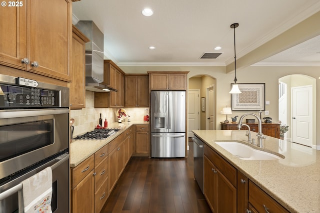 kitchen featuring a sink, light stone countertops, arched walkways, stainless steel appliances, and dark wood-style flooring