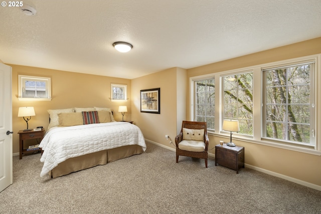 carpeted bedroom featuring a textured ceiling and baseboards