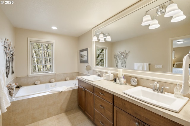 full bath with a sink, double vanity, a bath, and tile patterned floors