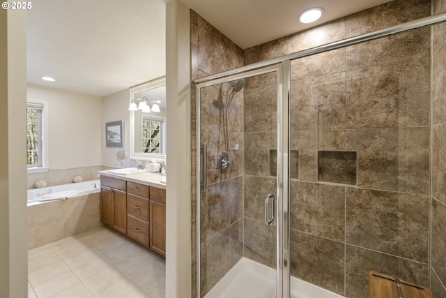 full bath featuring a bath, tile patterned flooring, a stall shower, and vanity