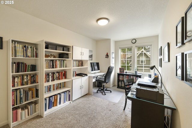 carpeted home office with a textured ceiling