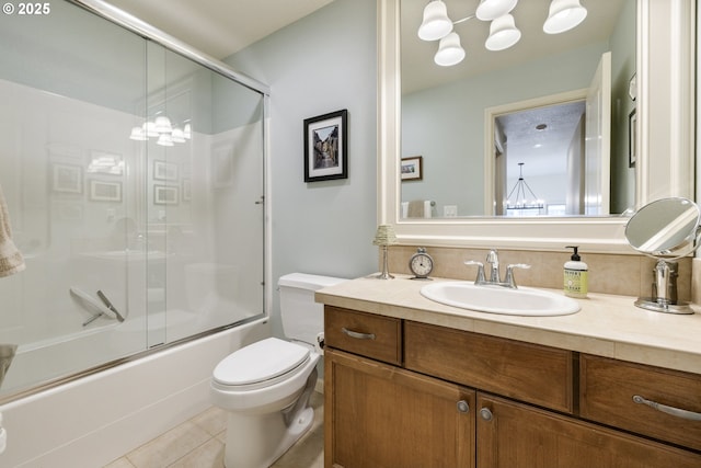 bathroom with vanity, a notable chandelier, tile patterned floors, toilet, and combined bath / shower with glass door