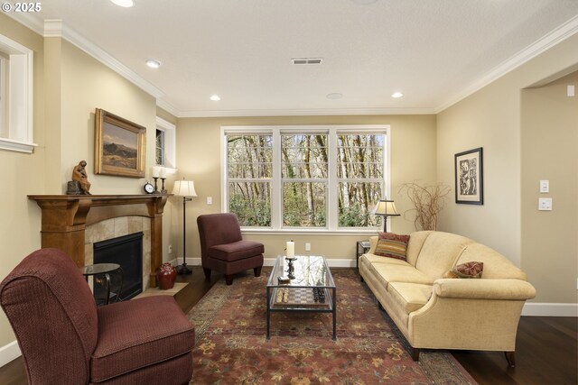 living room with baseboards, wood finished floors, a fireplace, and ornamental molding