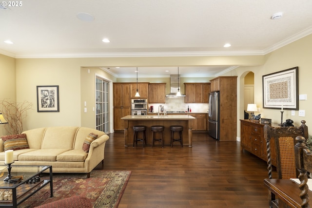 living room featuring arched walkways, ornamental molding, and dark wood-style flooring