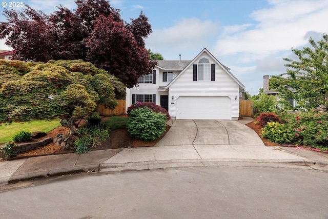 traditional-style house featuring fence, concrete driveway, and a garage