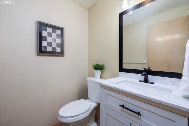 half bathroom featuring vanity and toilet