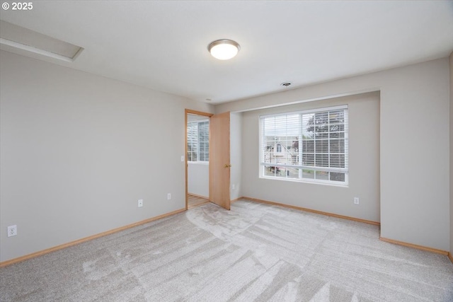 carpeted empty room featuring baseboards