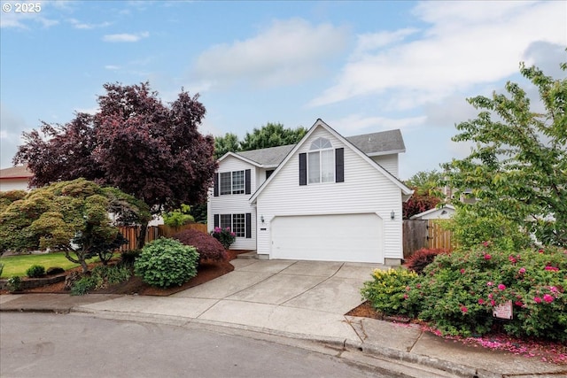 traditional-style house with fence, an attached garage, driveway, and roof with shingles