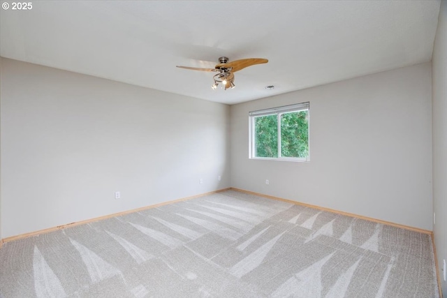 carpeted empty room featuring ceiling fan and baseboards