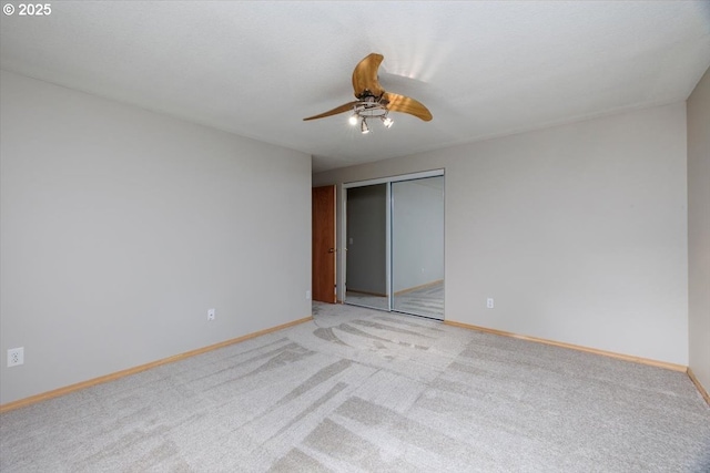 unfurnished room with a ceiling fan, light colored carpet, and baseboards