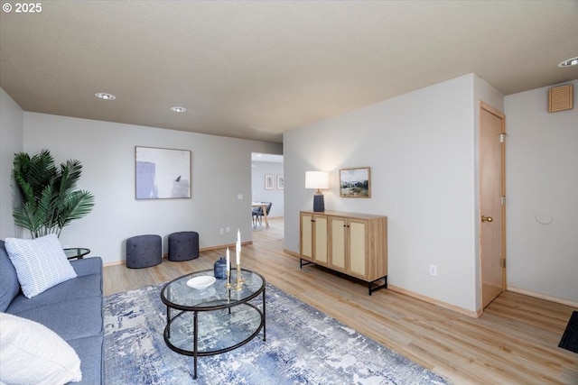 living area featuring light wood-style flooring, baseboards, and recessed lighting