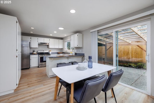 dining room with light wood-style floors and recessed lighting