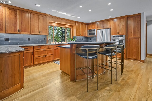 living area featuring a chandelier, light wood finished floors, a fireplace, a textured ceiling, and baseboards