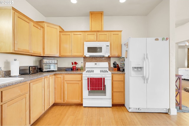 kitchen with sink, white appliances, light hardwood / wood-style floors, and light brown cabinets