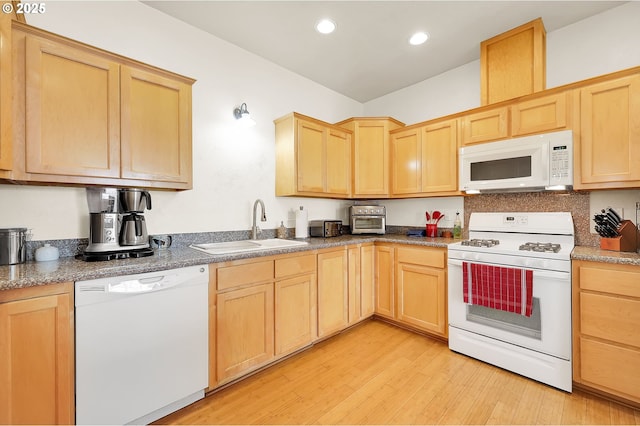 kitchen featuring white appliances, light brown cabinetry, sink, and light wood-type flooring