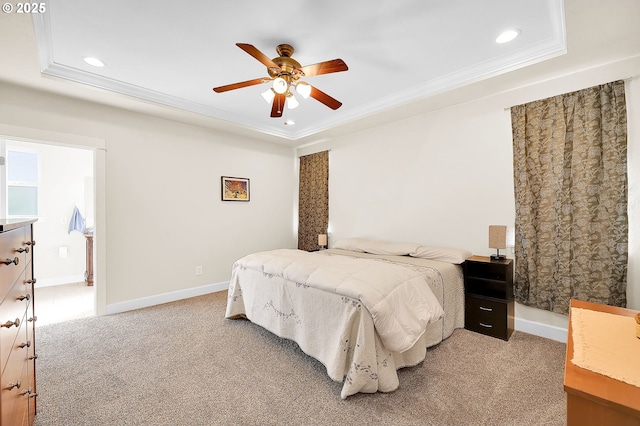 bedroom featuring a raised ceiling, ornamental molding, light colored carpet, and ceiling fan