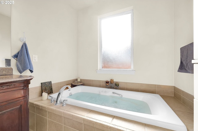 bathroom featuring tiled tub and vanity