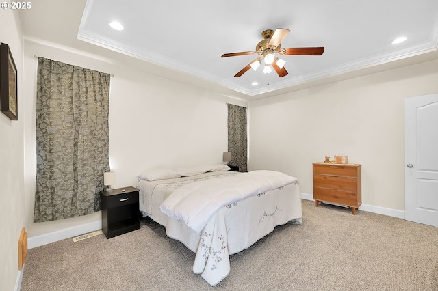 carpeted bedroom featuring ceiling fan, ornamental molding, and a tray ceiling