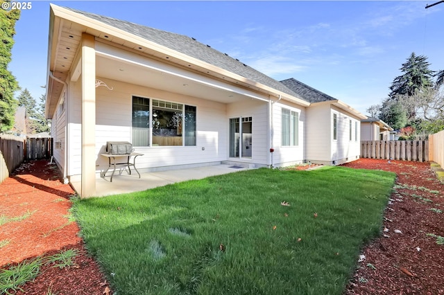 back of house featuring a patio and a yard