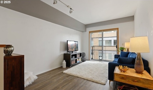 living area featuring baseboards, track lighting, and wood finished floors