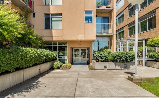 view of exterior entry featuring stucco siding and french doors