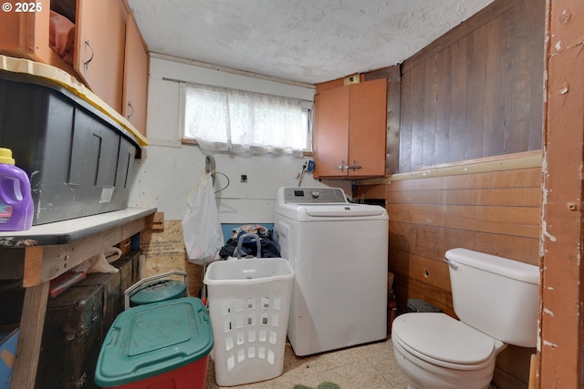 laundry area with a textured ceiling, laundry area, washer / dryer, and wooden walls