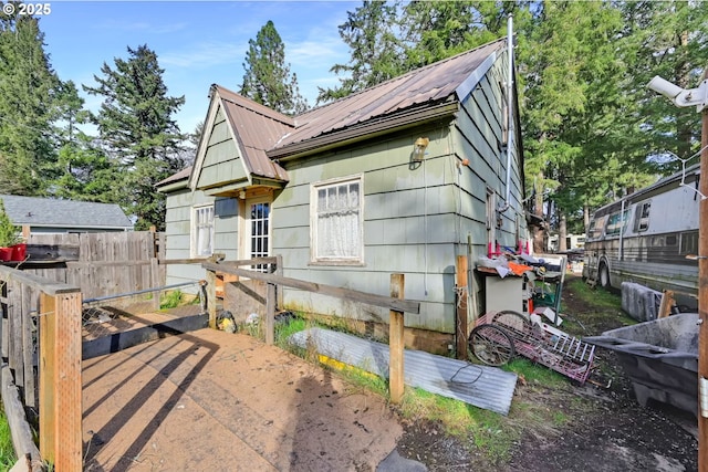 exterior space with metal roof and fence