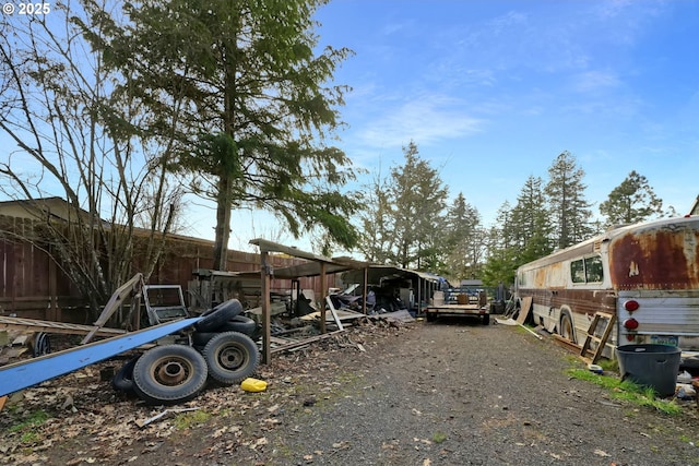 view of vehicle parking with driveway and fence