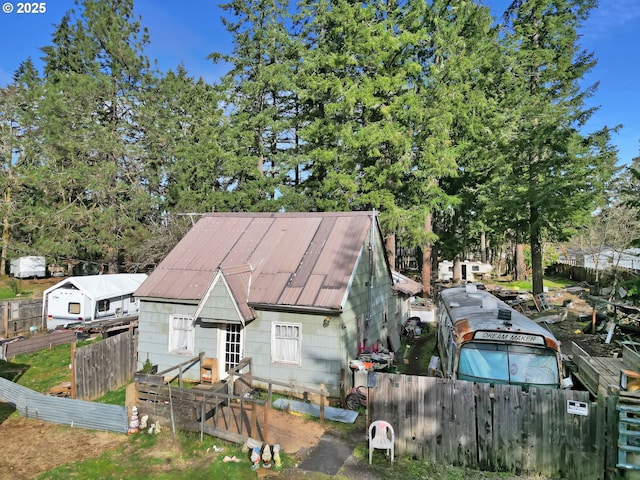 view of front of home featuring fence and metal roof