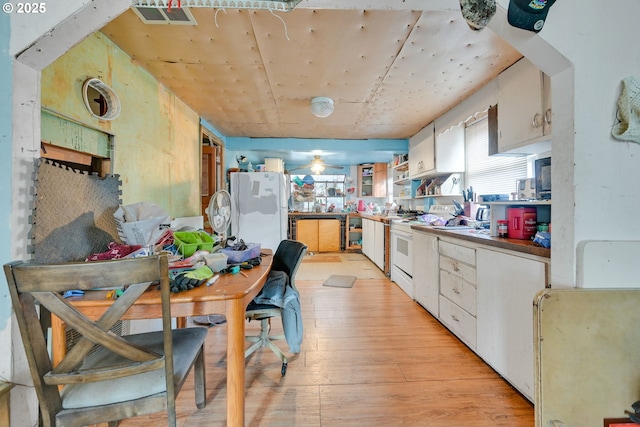 kitchen with white appliances, light wood finished floors, visible vents, white cabinetry, and open shelves