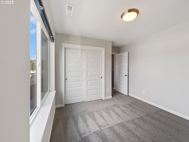 unfurnished bedroom featuring carpet flooring, visible vents, a closet, and baseboards