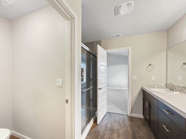 bathroom featuring vanity, baseboards, toilet, visible vents, and wood finished floors