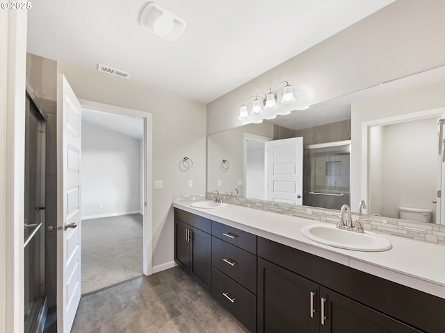 full bathroom featuring a stall shower, wood finished floors, a sink, and visible vents