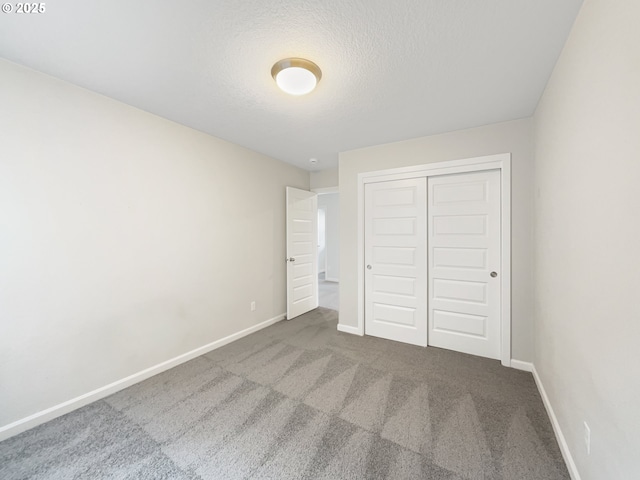 unfurnished bedroom featuring carpet flooring, a closet, and baseboards