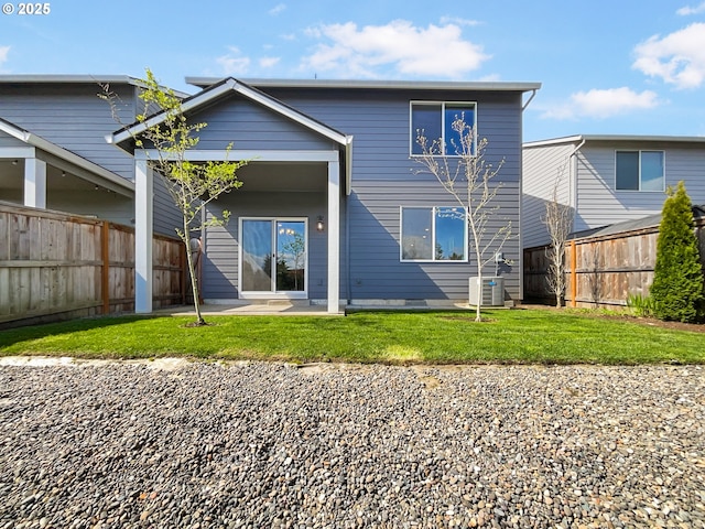 back of property with a yard, fence, central air condition unit, and a patio area