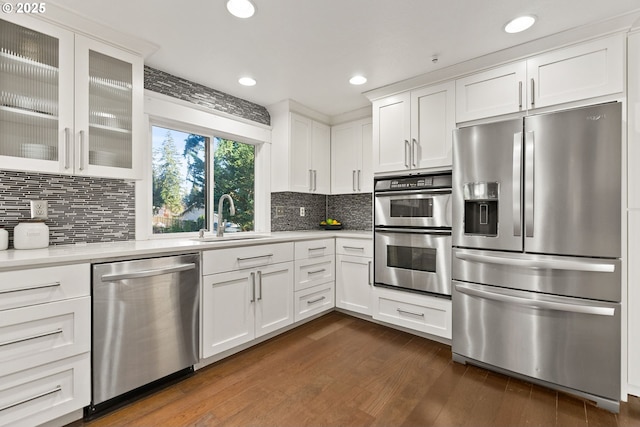 kitchen featuring light countertops, appliances with stainless steel finishes, glass insert cabinets, and white cabinetry