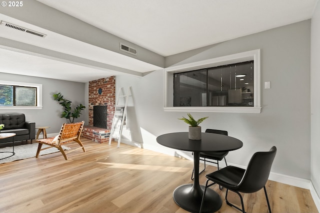 interior space featuring a fireplace, wood finished floors, visible vents, and baseboards