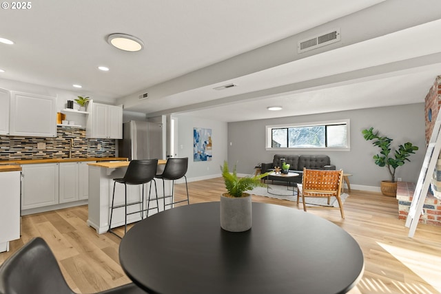 dining space featuring light wood-style floors, visible vents, and recessed lighting