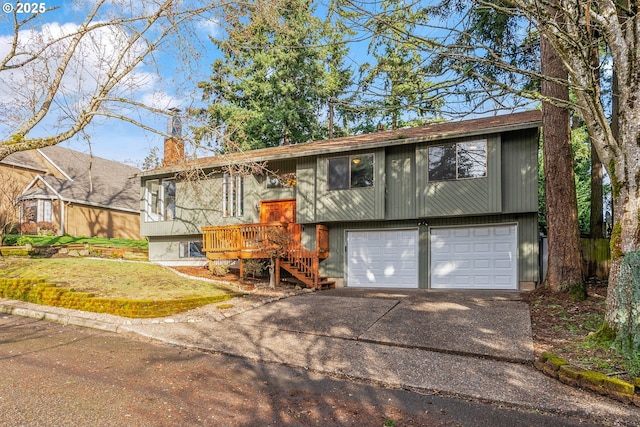 split foyer home featuring driveway, a chimney, and an attached garage