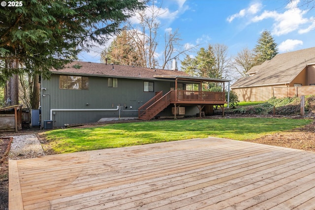 rear view of house with stairs, a yard, and a wooden deck