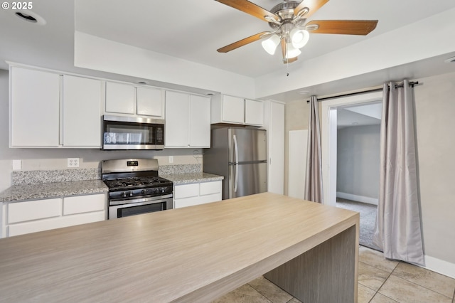 kitchen with ceiling fan, white cabinetry, light tile patterned floors, and appliances with stainless steel finishes