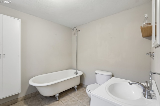 bathroom featuring sink, a bathtub, tile patterned flooring, and toilet