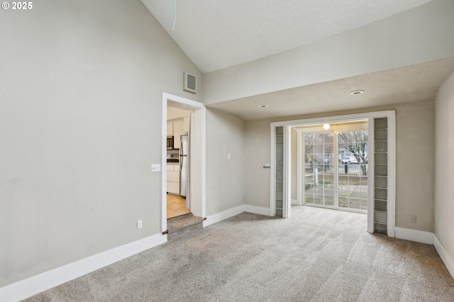 carpeted empty room with lofted ceiling