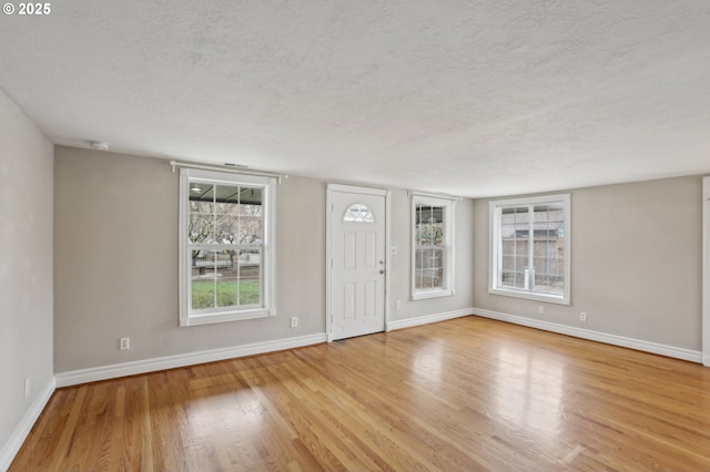 interior space with a textured ceiling and light hardwood / wood-style flooring