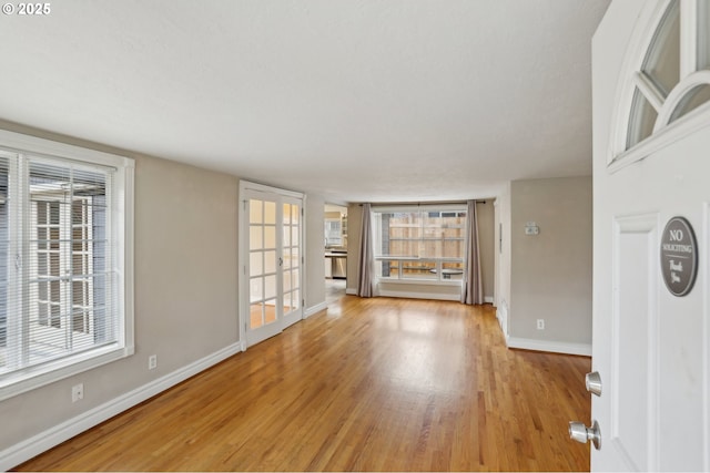 unfurnished living room with a healthy amount of sunlight and light hardwood / wood-style flooring