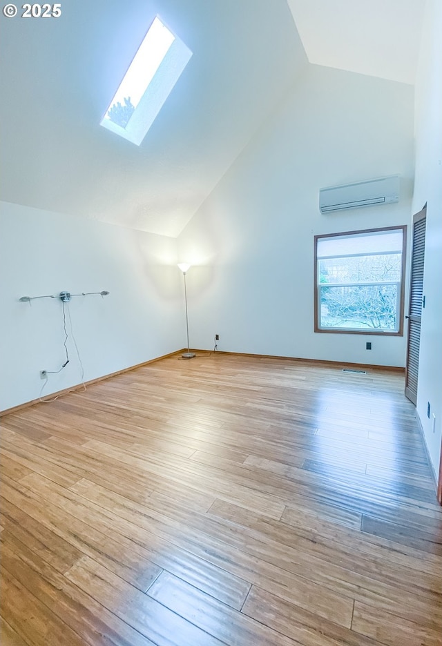 3241 SW Spring Garden St, Portland, OR 97219 - additional living space with a wall mounted AC, vaulted ceiling, a skylight, and wood finished floors